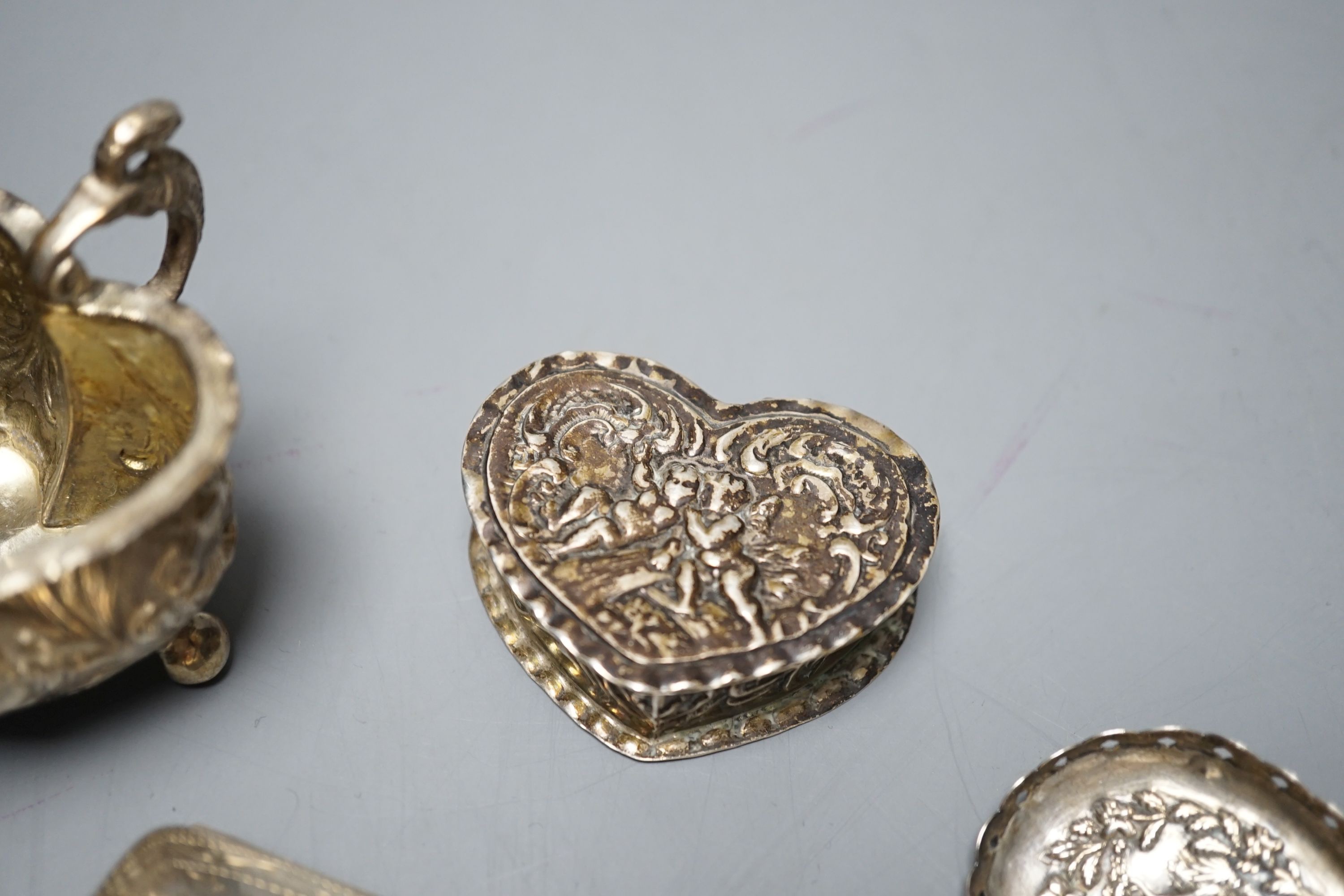 A George III silver caddy spoon, with associated bowl, handle marked for John Bettridge, Birmingham, 1817, 76mm, a late 19thcentury Hanau white metal small jug, an embossed white metal heart shape box and a white metal p